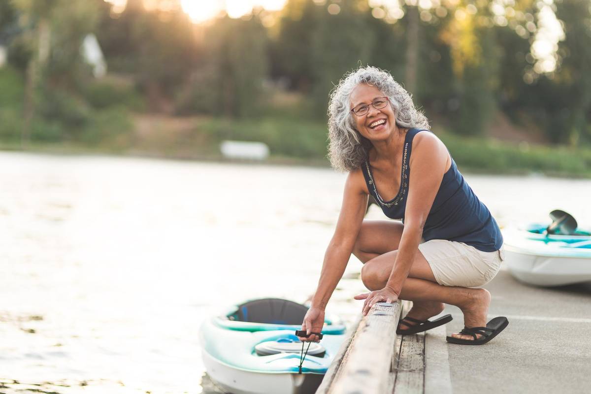Happy senior woman on a kayaking trip