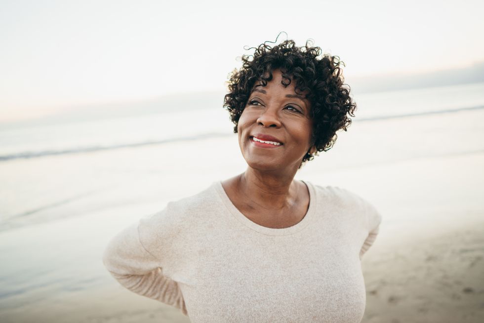 happy woman standing on the beach enjoying nature