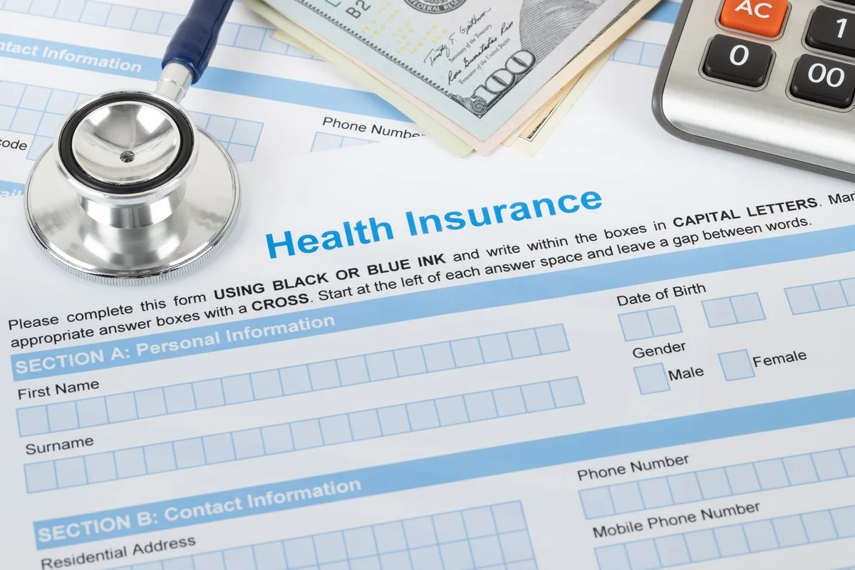 Health insurance application form with stethoscope and calculator