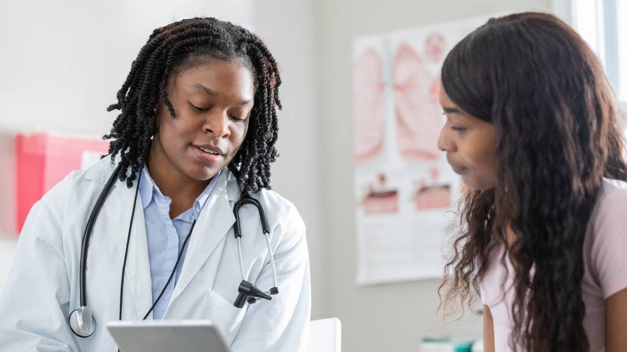 Healthcare professional uses digital tablet to help patient understand options during appointment