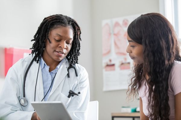 Healthcare professional uses digital tablet to help patient understand options during appointment