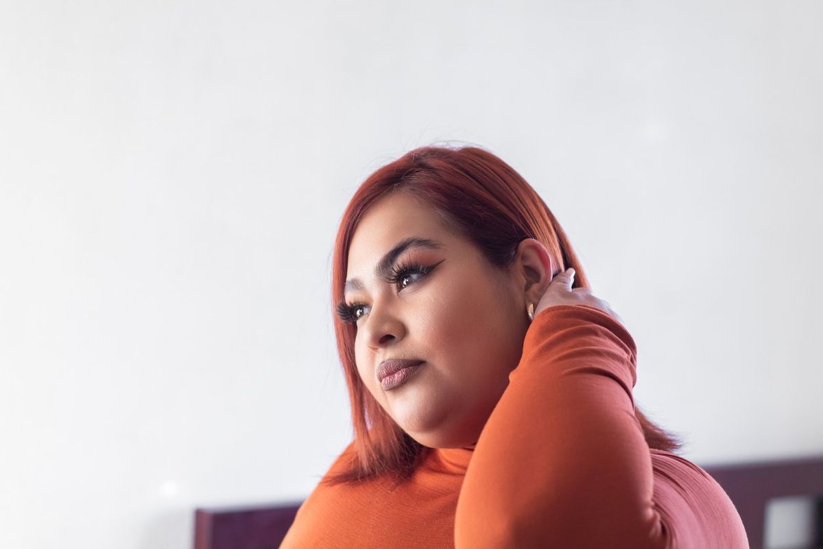 hispanic overweight woman in profile touching her hair