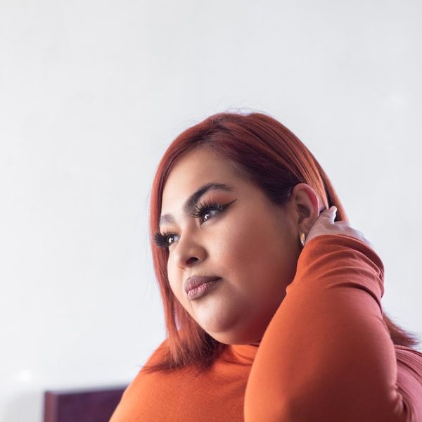 hispanic overweight woman in profile touching her hair