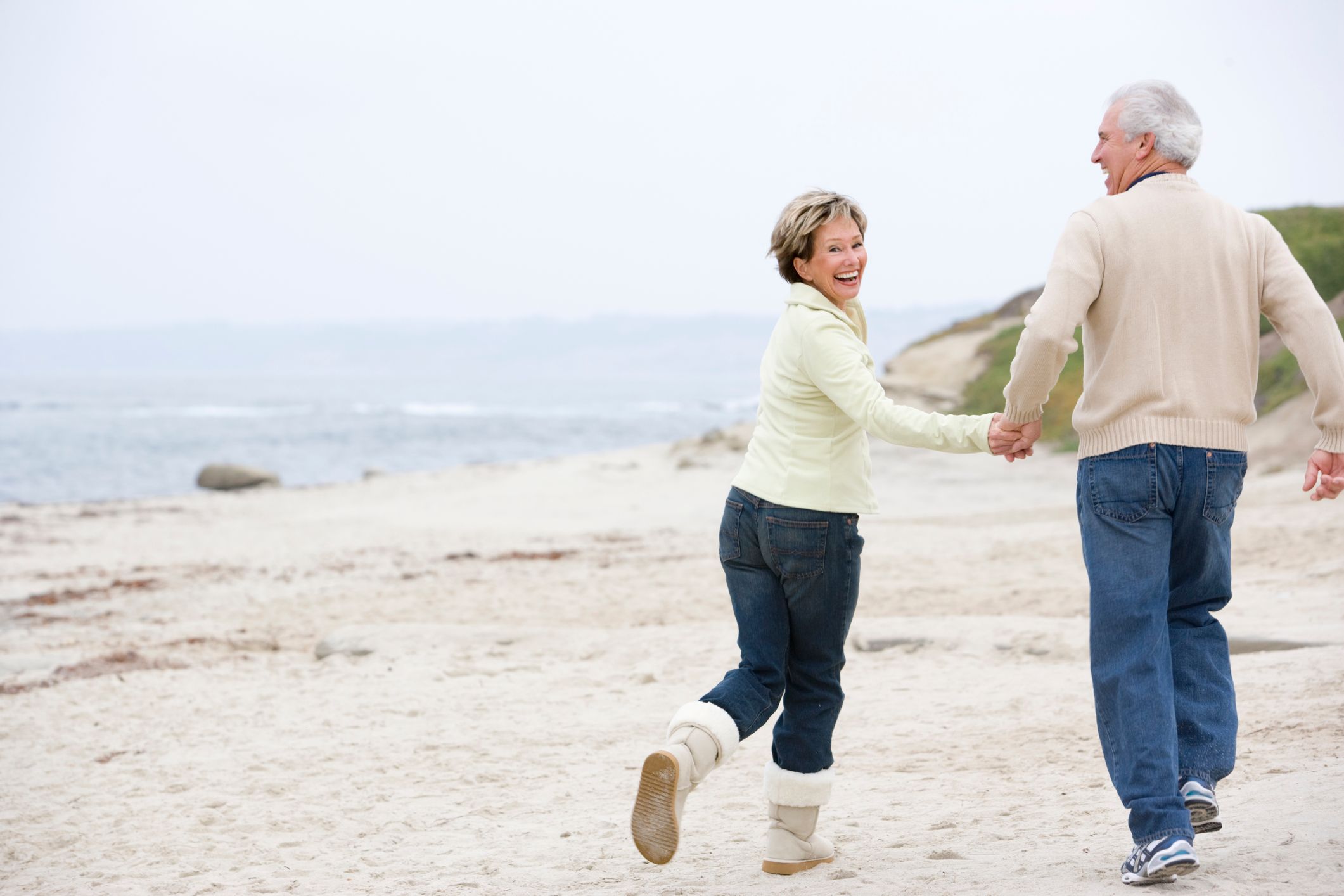 older couple running on the beach