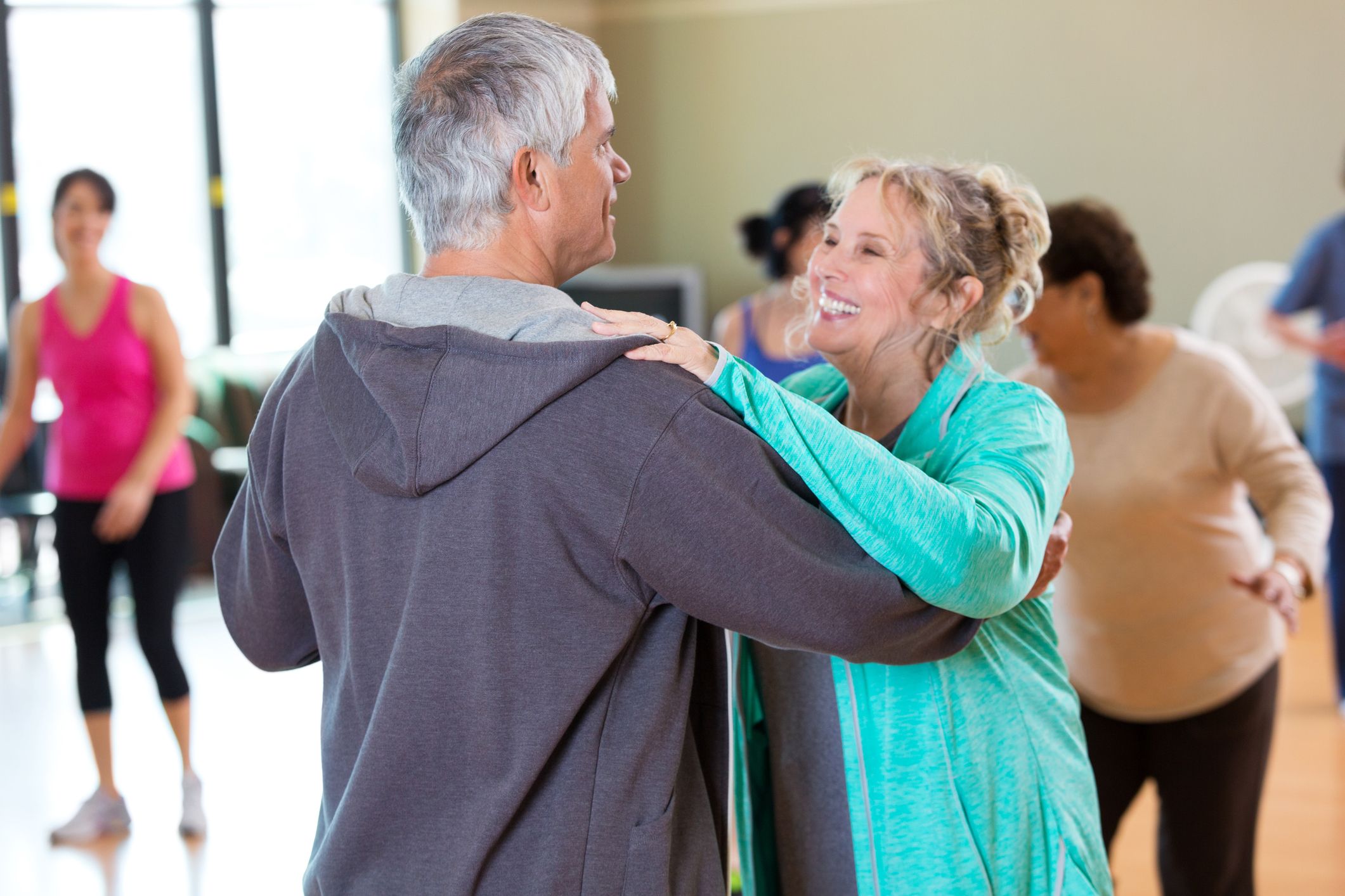 Happy active senior couple take ballroom dancing lessons at senior center