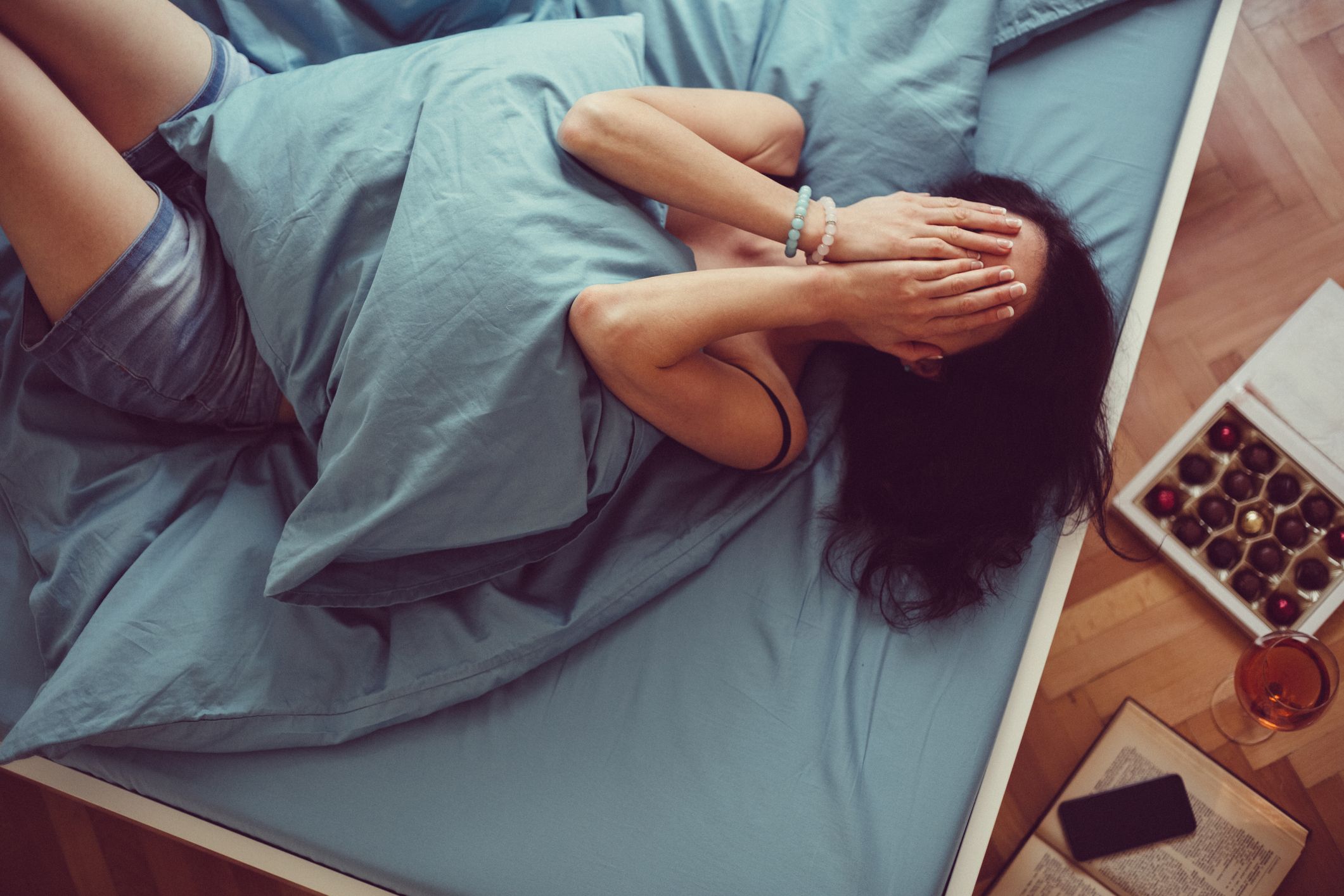 anxious woman in bed with hands on face