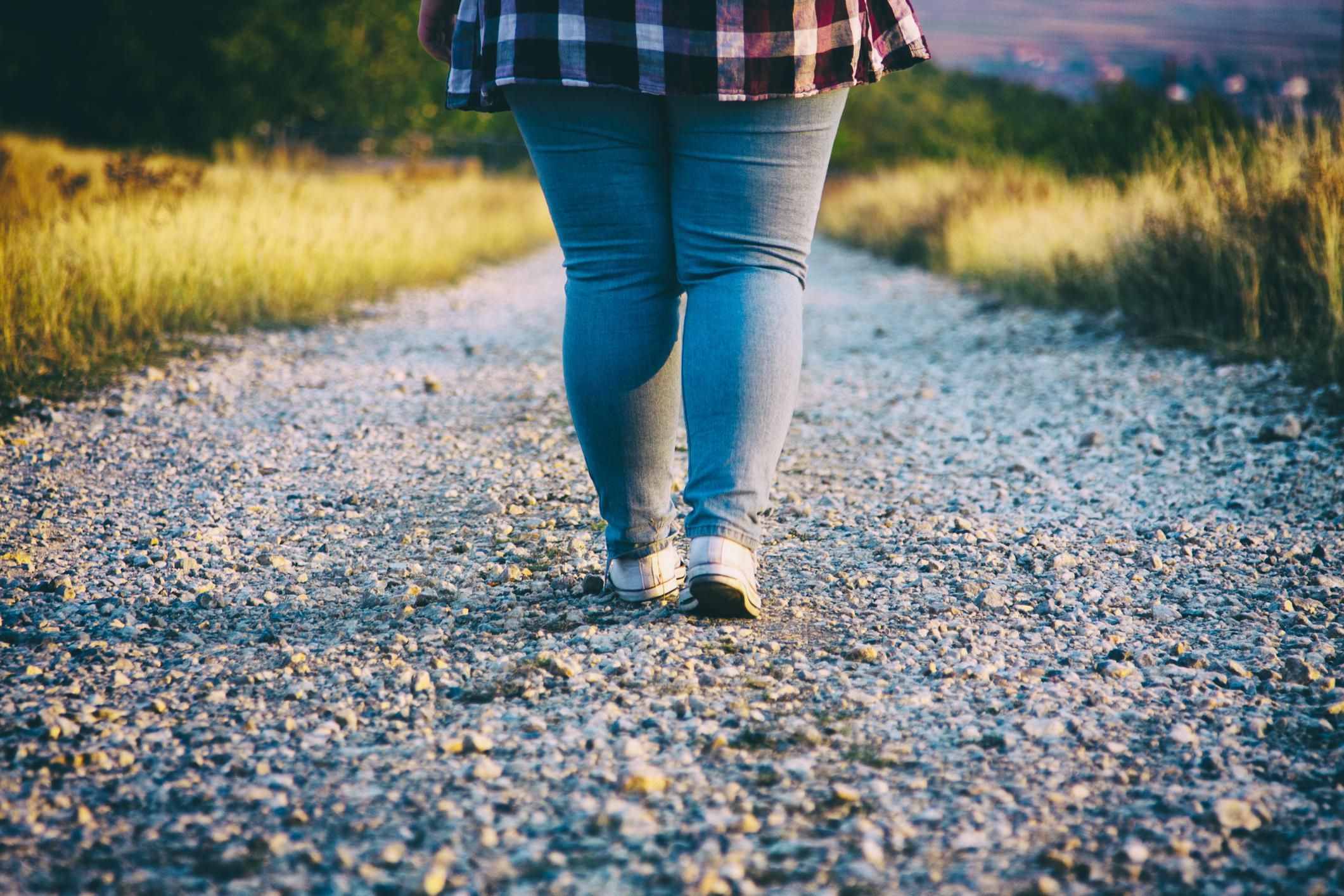 obese Young woman walking on country road