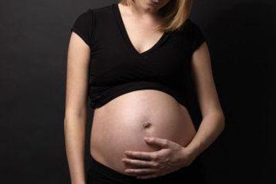 woman looking at her pregnant belly