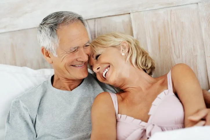 Cheerful senior woman resting on mature man's shoulder