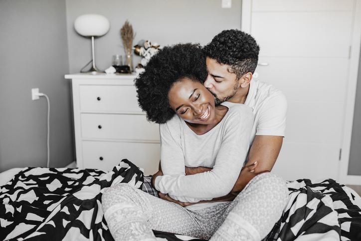 Young African American couple embracing in bed
