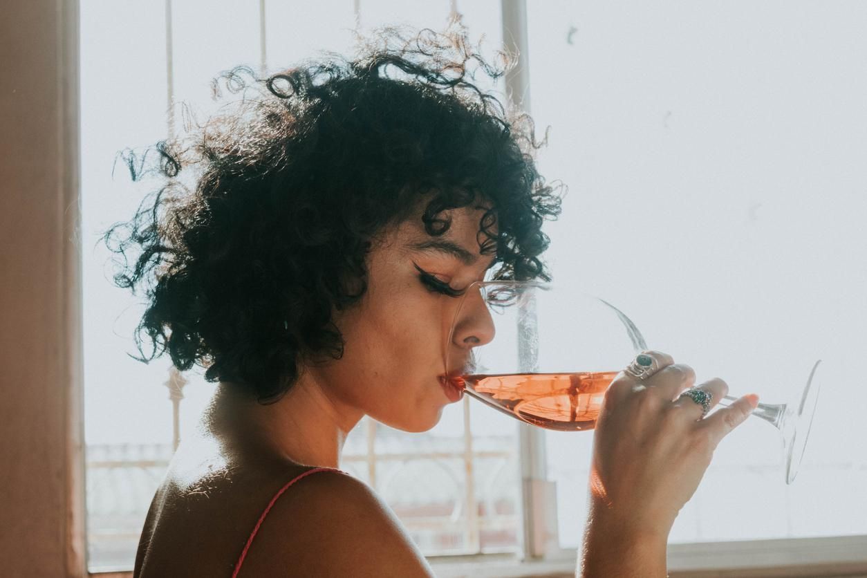 young woman drinking rose wine