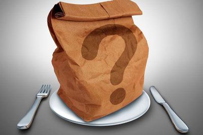 brown paper bag with a question mark on a plate