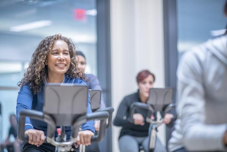 woman on an exercise bike at a group fitness class.