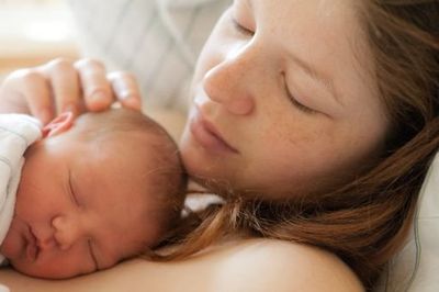 woman holding her sleeping infant