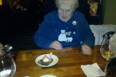 grandmother happily looking at a piece of birthday cake