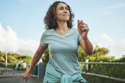 Smiling mature woman out for a power walk in summer
