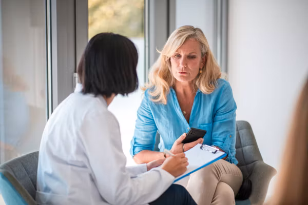 In a doctor's office with a mature Caucasian female patient and an Asian female doctor.