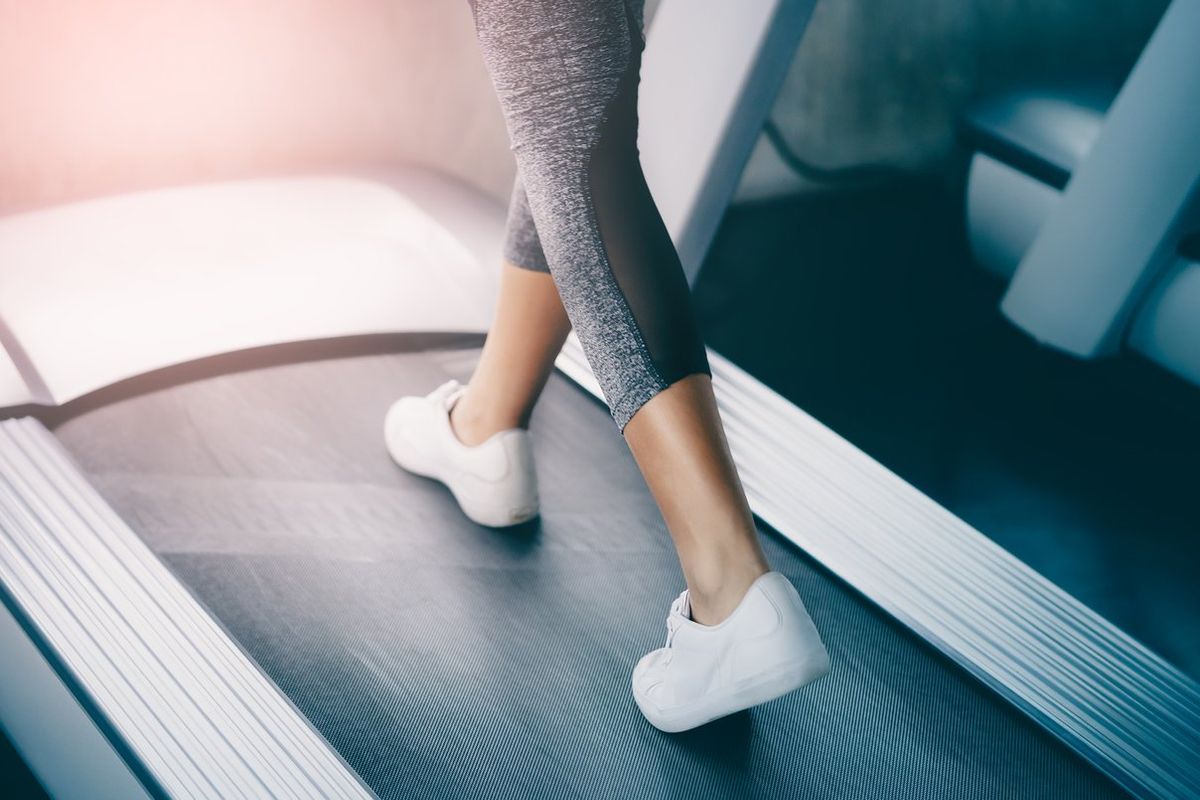 Indoor runner legs is walking slowly on the treadmill for light exercise
