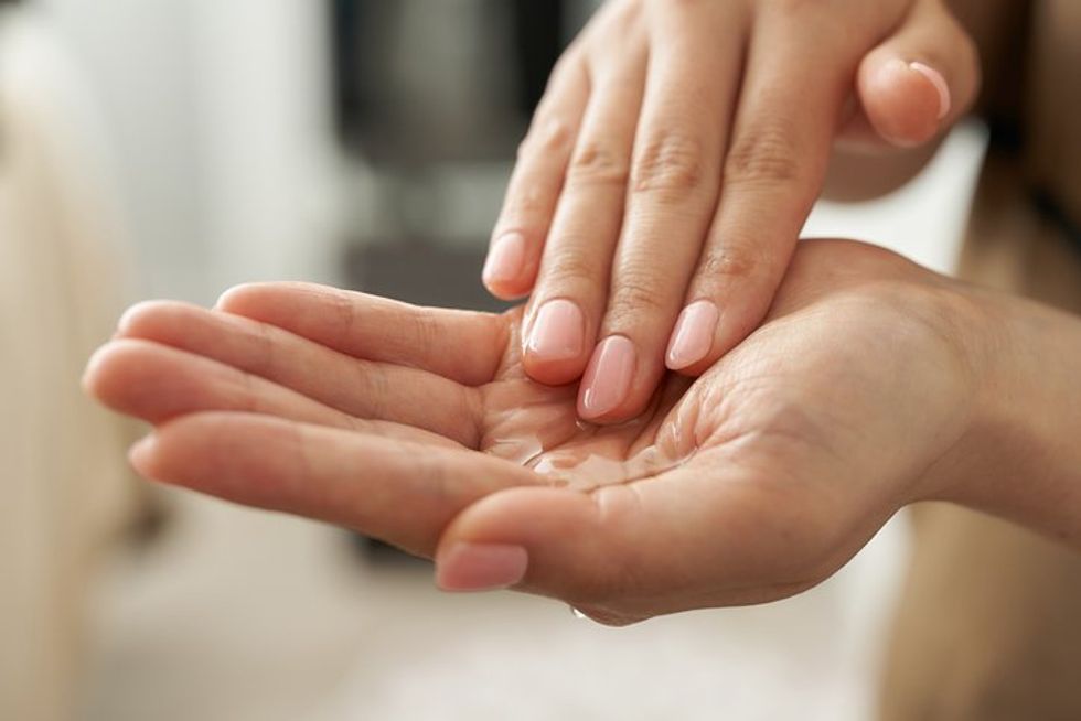 Japanese esthetician holding a massage oil in her hand