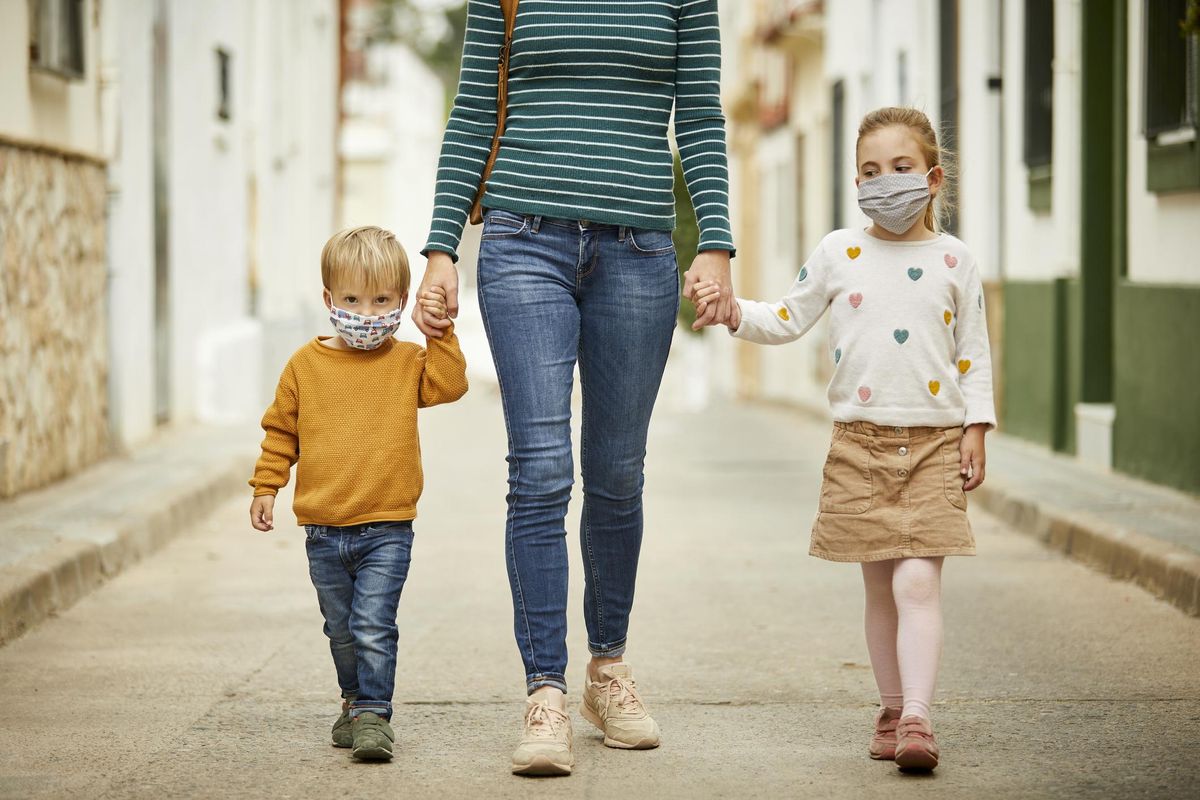 Kids with mother walking on the street with face masks