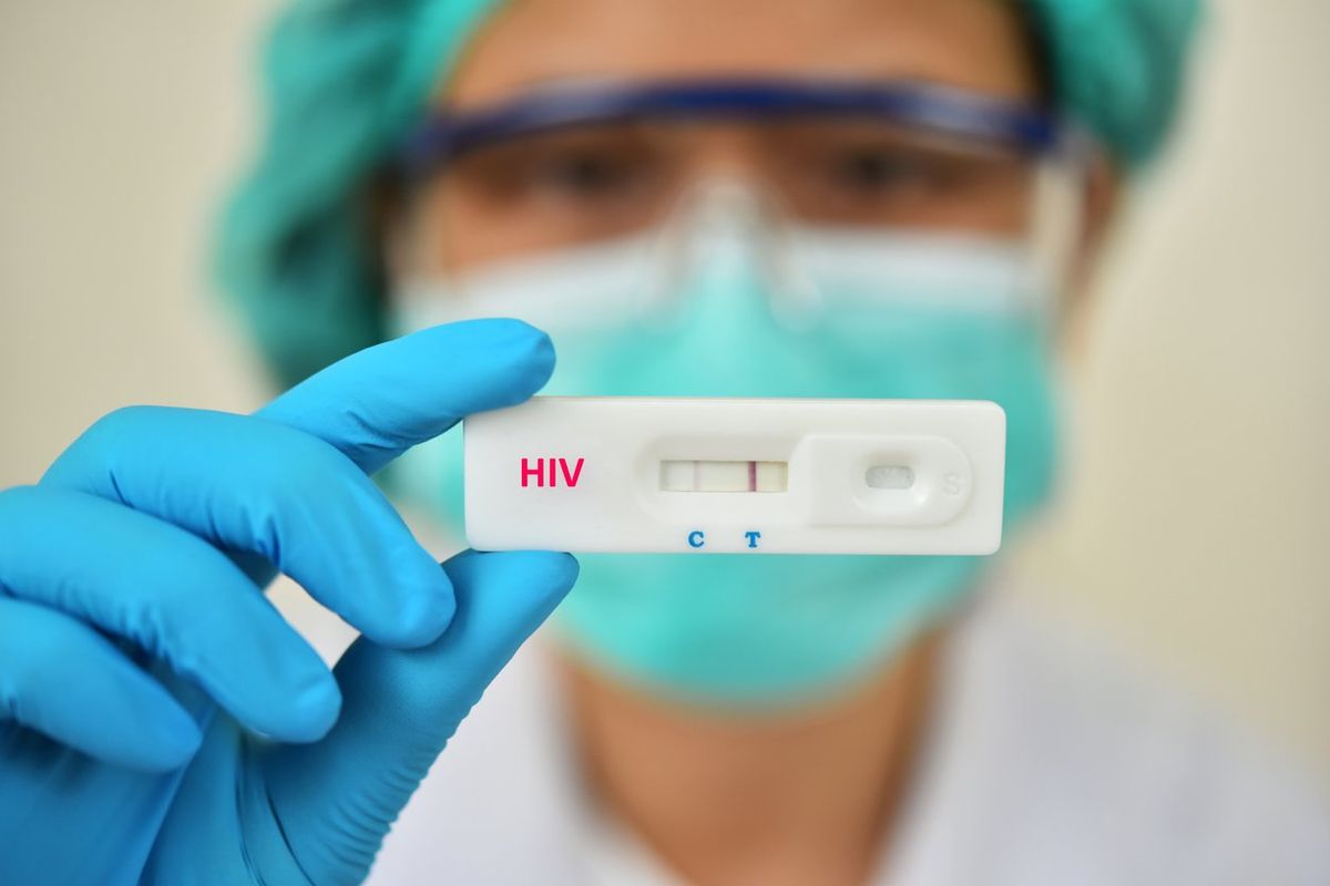 Lab technician holding HIV rapid device test, the result showed positive