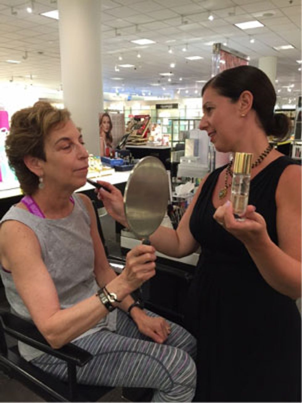 Lorraine blends makeup with a blending brush and with her fingertips.