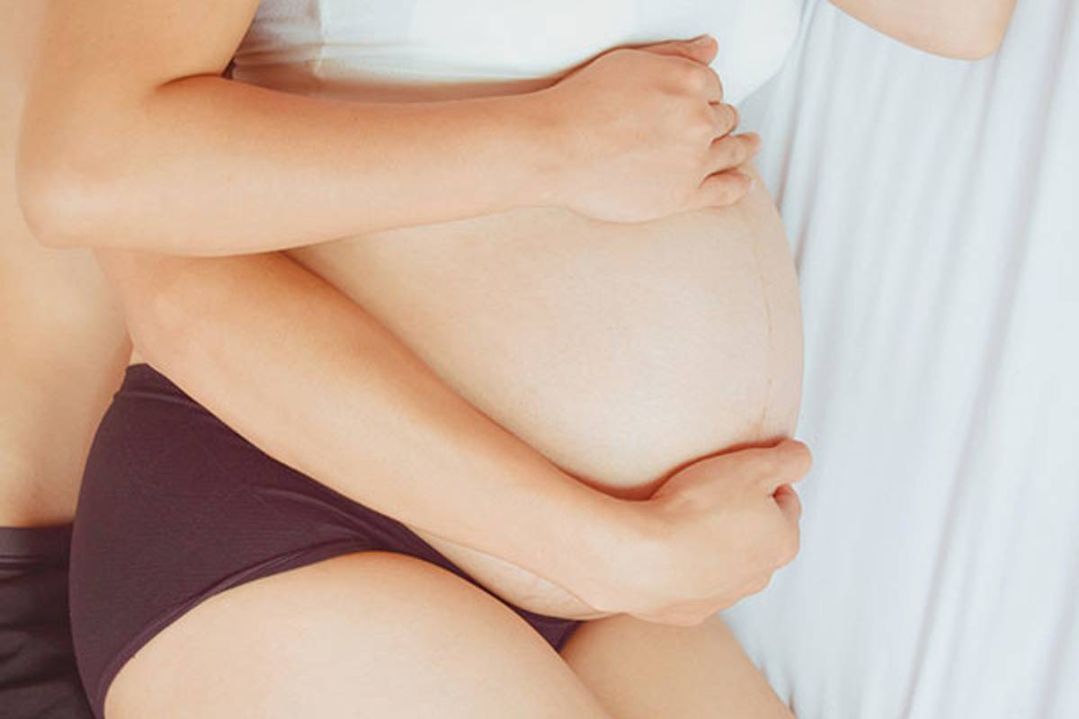 loving pregnant couple on bed