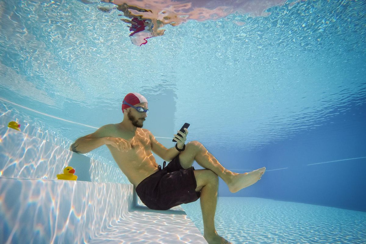 man using his cell phone underwater