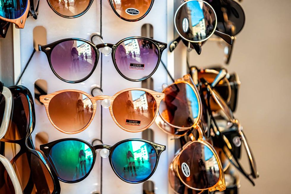 many modern colorful sunglasses in outdoor market shop
