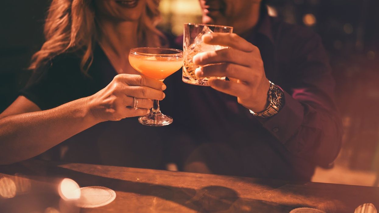 mature couple toasting with drinks at bar
