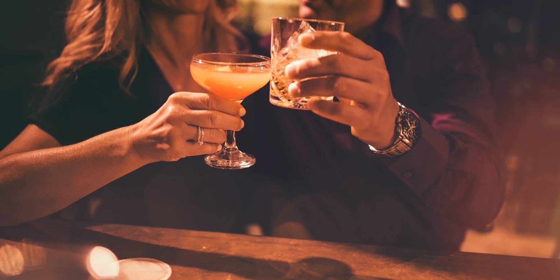 mature couple toasting with drinks at bar