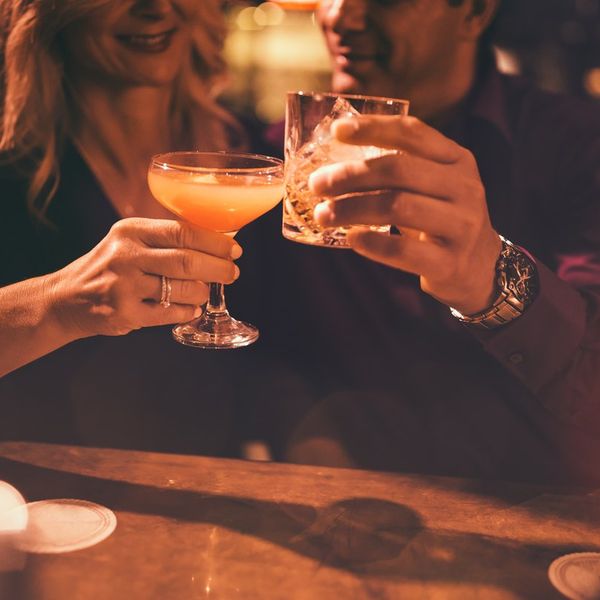 mature couple toasting with drinks at bar