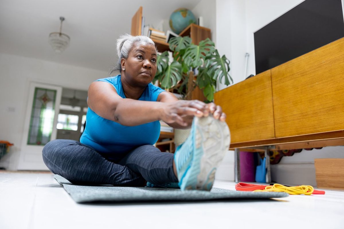 mature woman doing stretching exercises at home