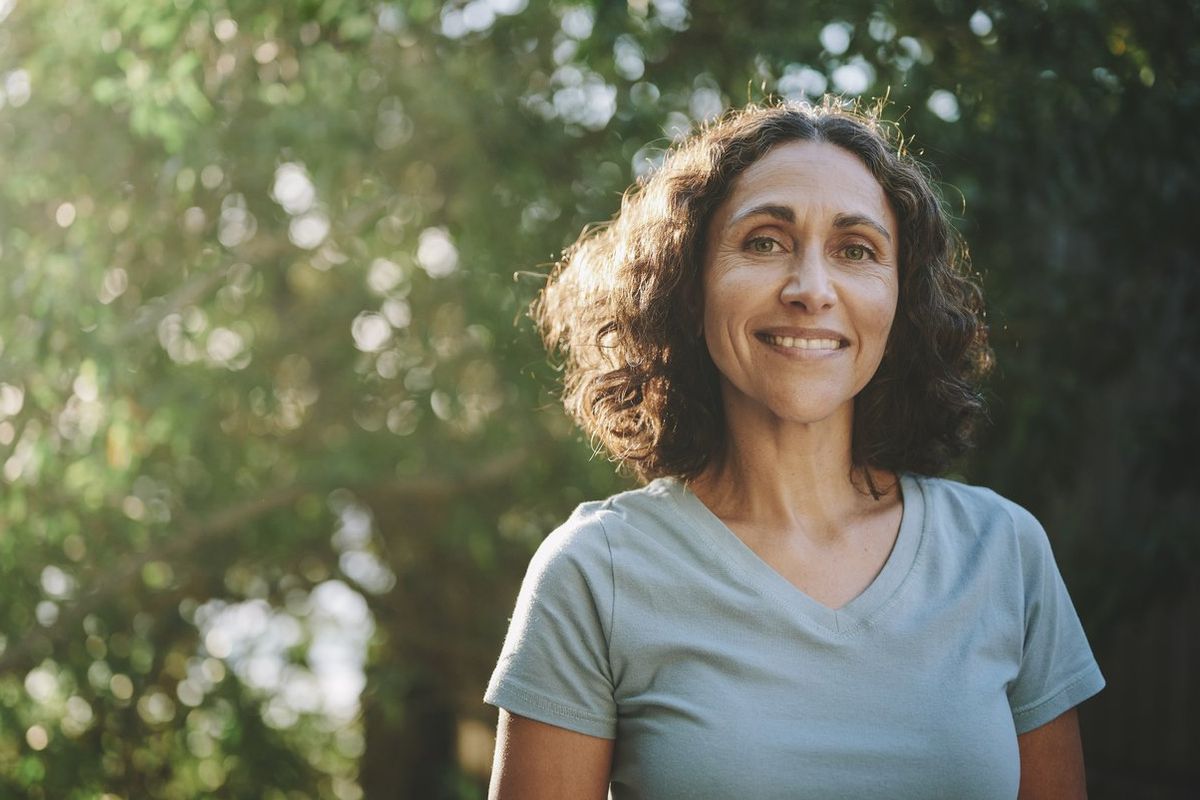 mature woman standing in a park outdoors in the summertime
