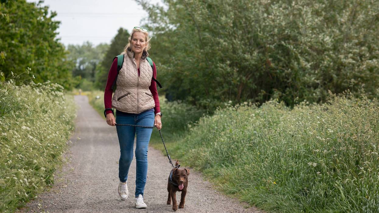 Mature Woman Walking Her Patterdale Terrier