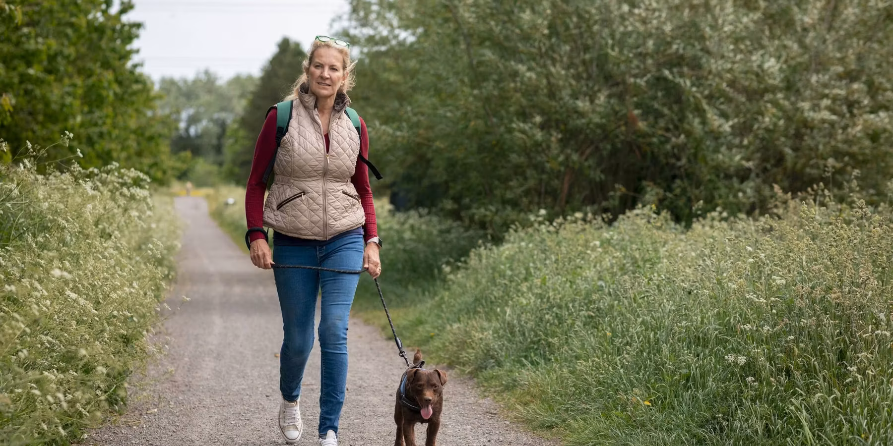 Mature Woman Walking Her Patterdale Terrier