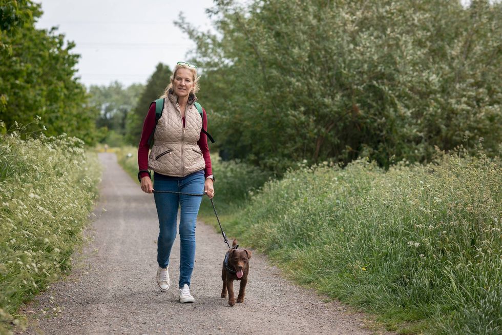 mature woman walking her patterdale terrier