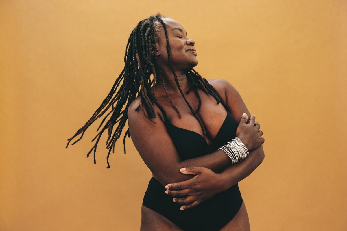 Mature woman with dreadlocks embracing her natural and ageing body