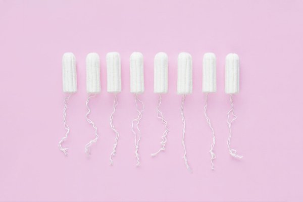 Menstrual period concept. Woman hygiene protection. Cotton tampons on pink background.