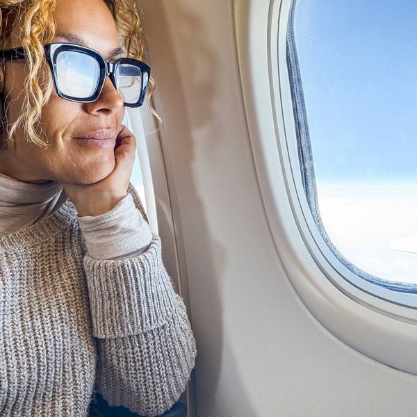 middle-aged woman listens to music and relaxes while sitting in a airplane seat