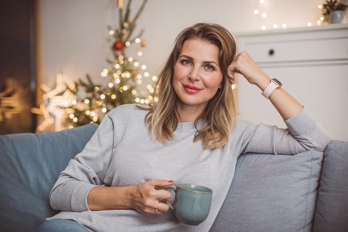 Middle aged woman sitting on the couch with a cup of coffee 