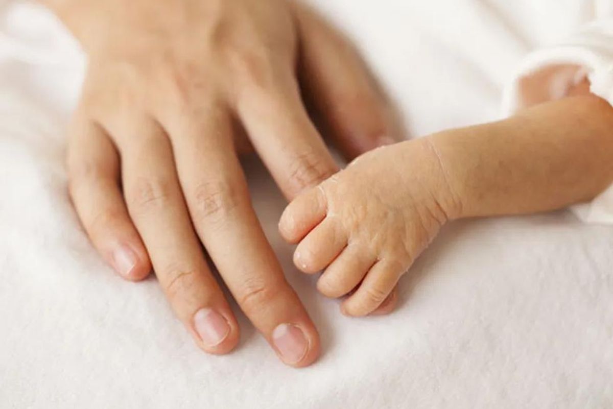 mom holding newborn hand