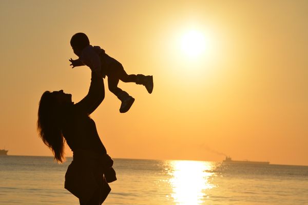 mother and child in front of the ocean