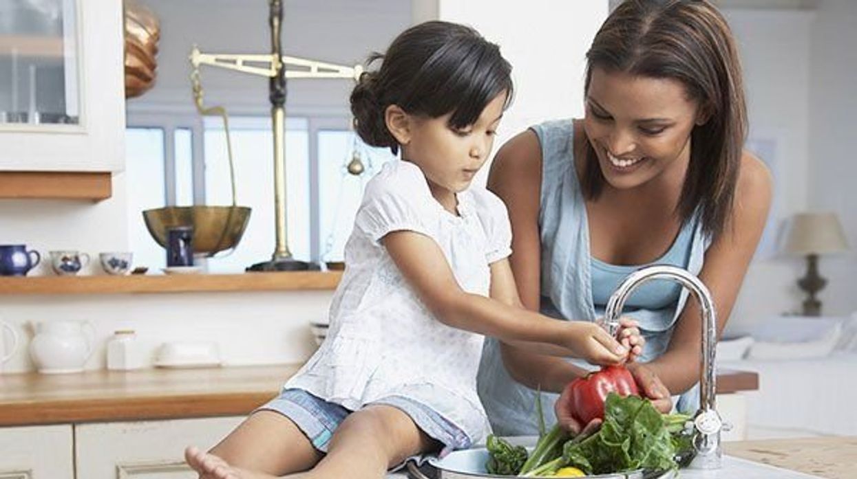 mother and daughter in the kitchen washing vegetables
