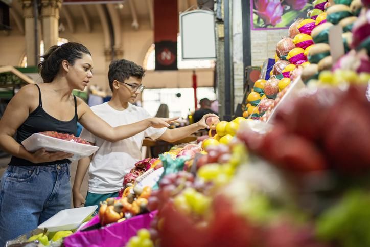 Seorang ibu dan putranya membeli buah-buahan di pasar kota