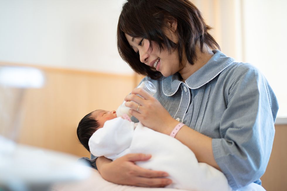 mother bottle feeding newborn