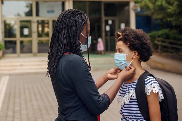 Mother Helping Daughter with Face Mask