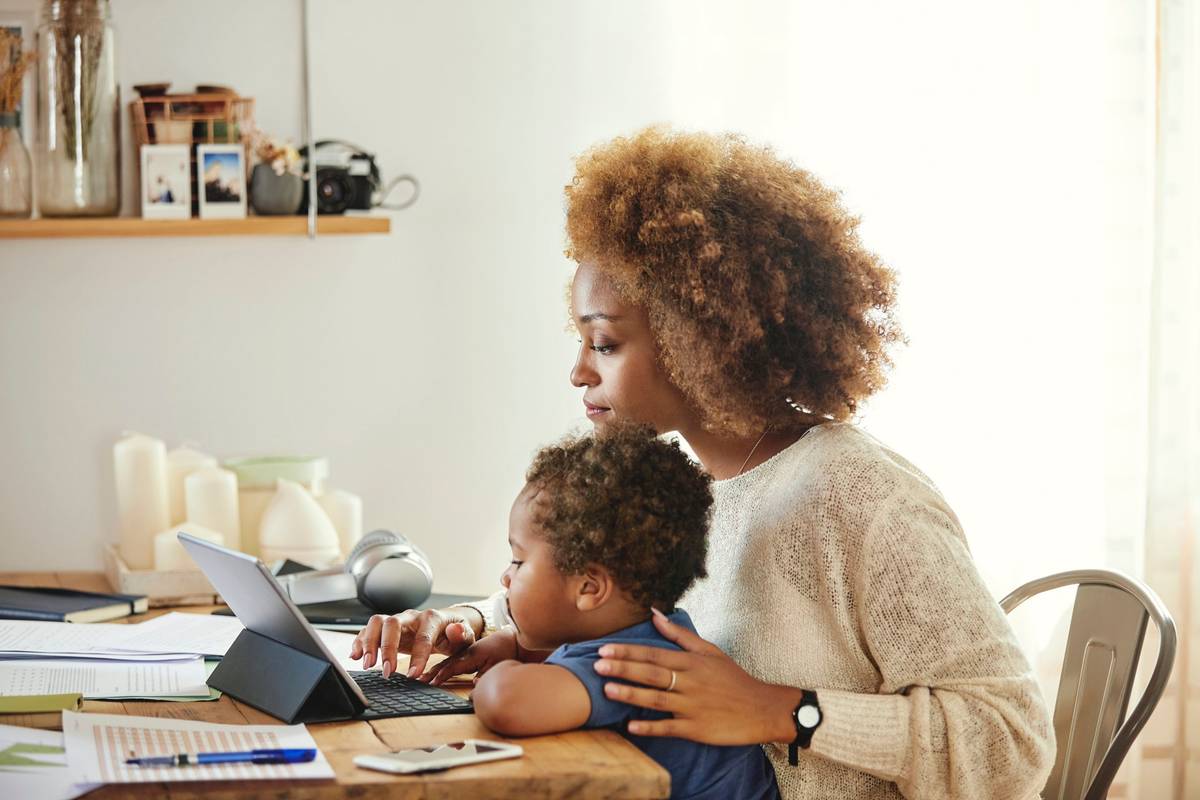 Mother with son working on digital tablet at home