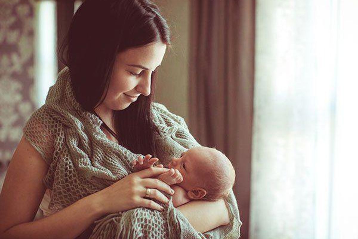 motherly looking lovingly at her newborn