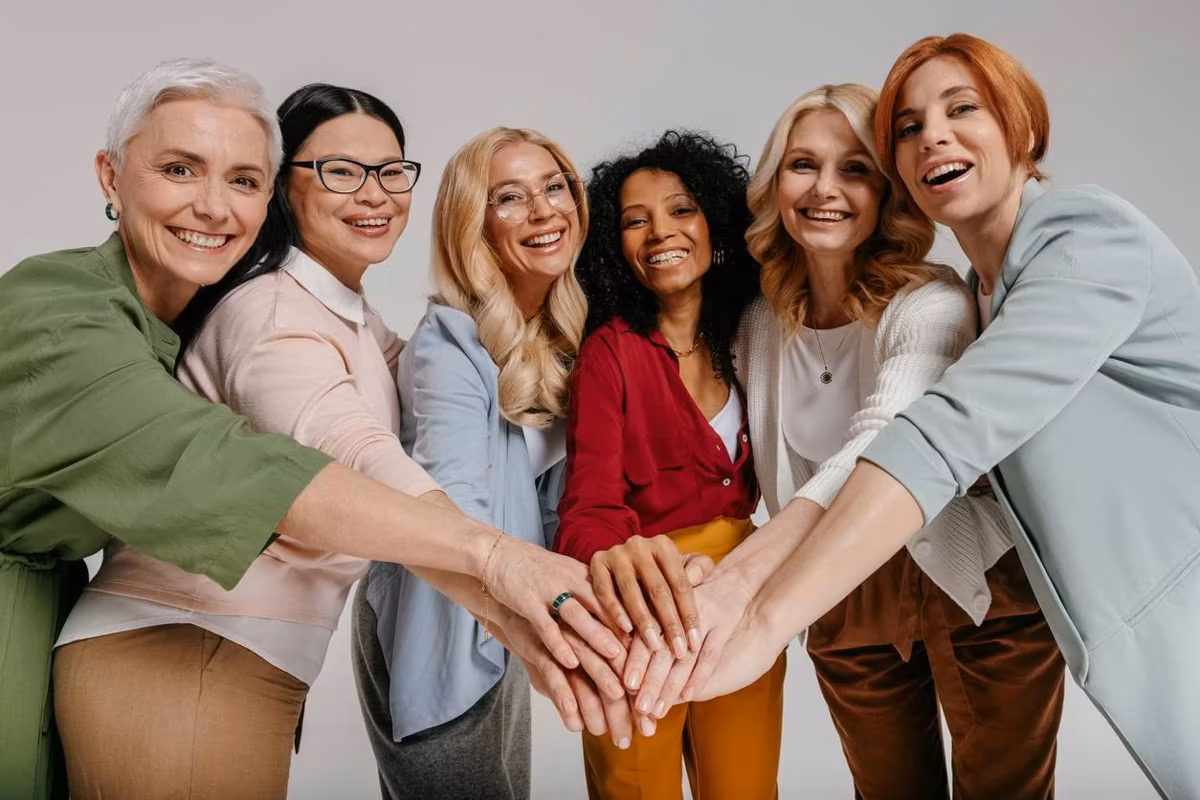 Multi-ethnic group of happy mature women holding hands
